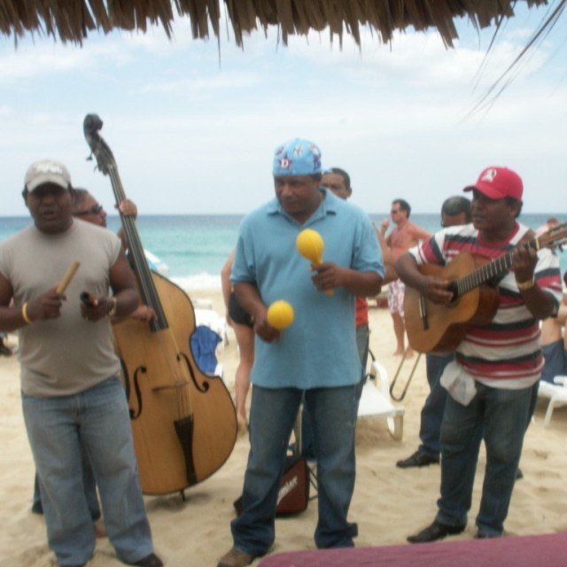 Group of people playing Moraccas, Bass, Guitar on Cuban beach